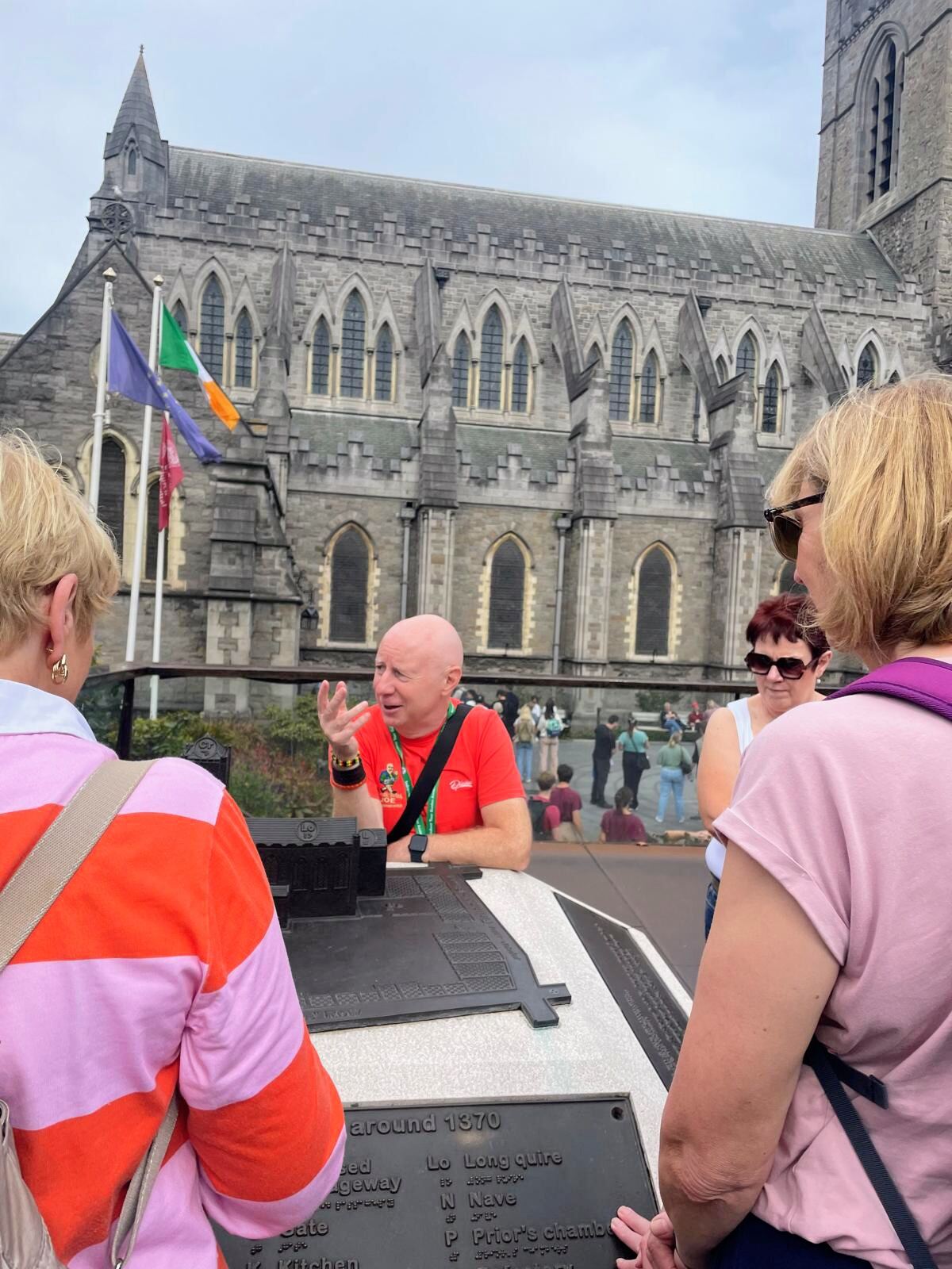 Joe talking to guests near a cathedral