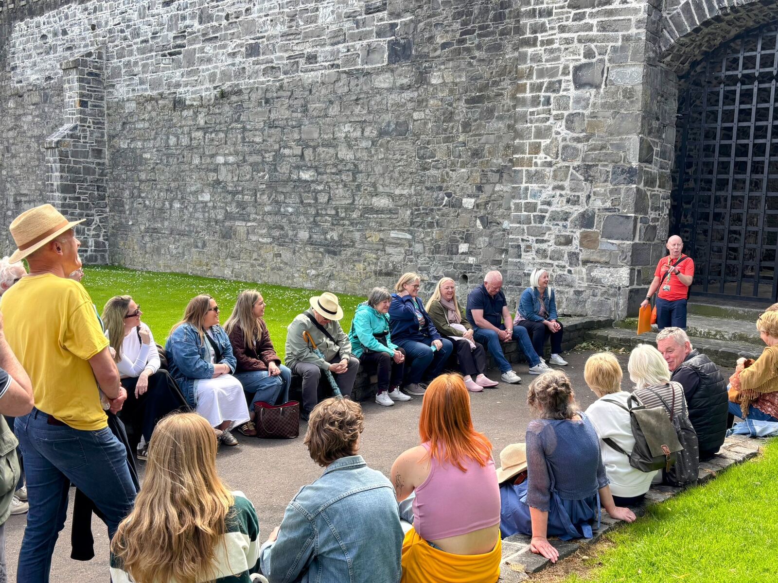 A group sitting by the old city wall listening to Joe