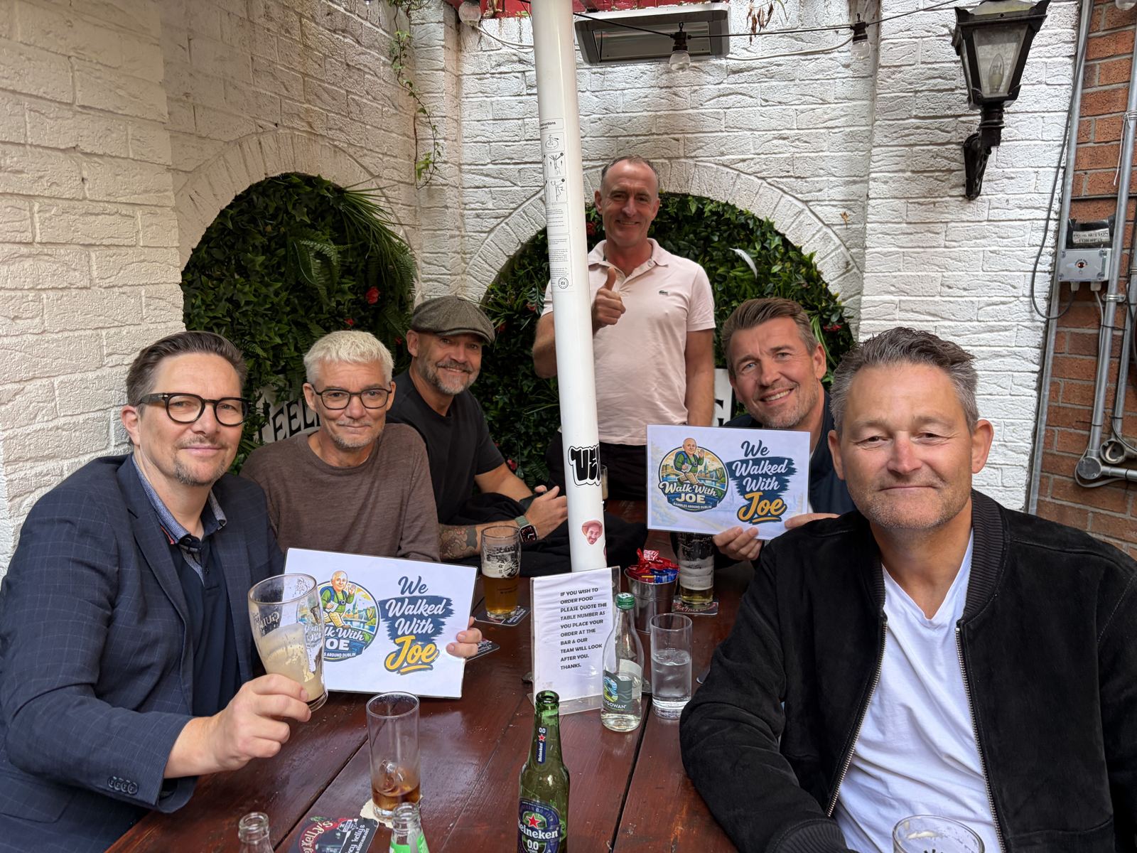 Guests in a pub with the sign