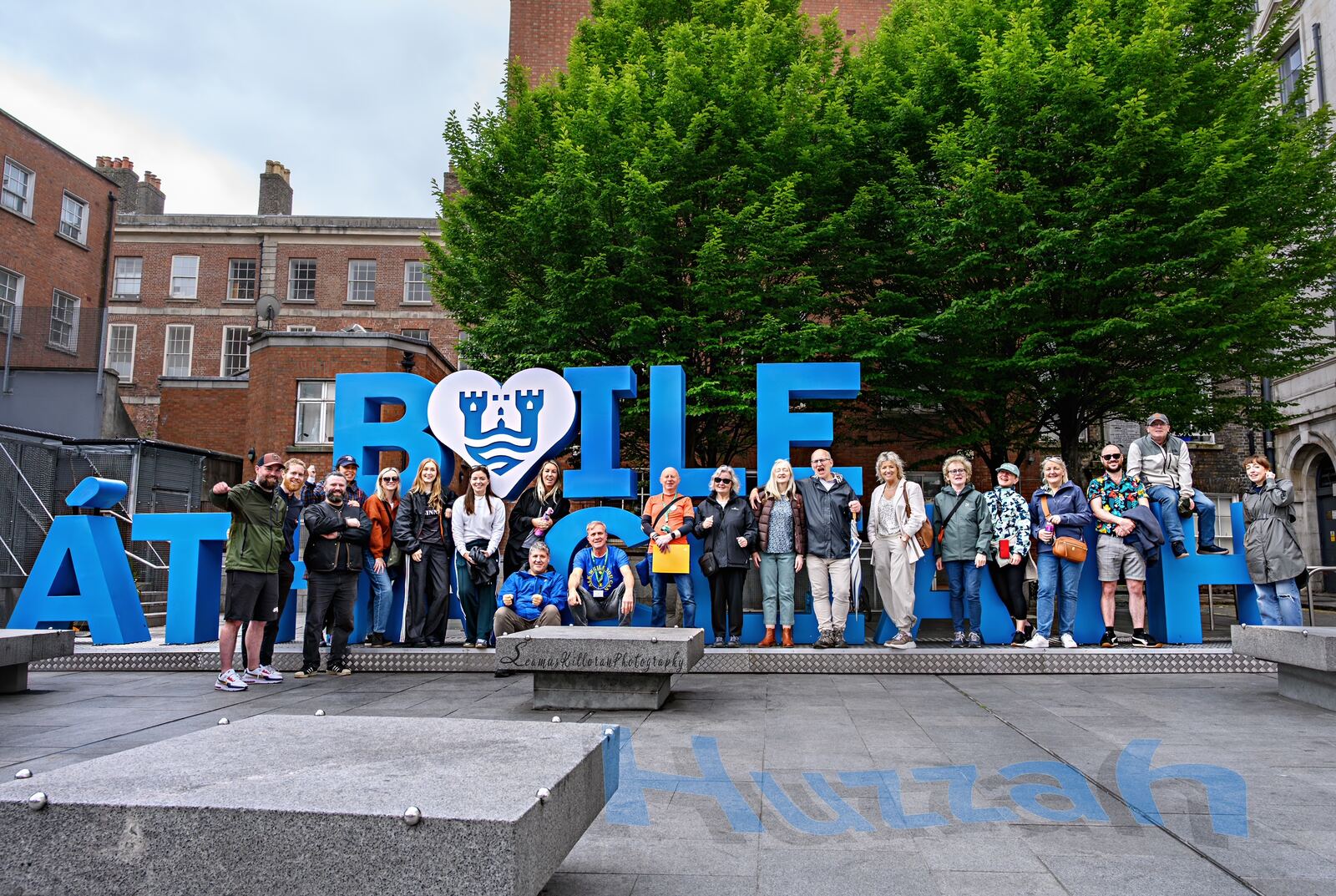 A Walk With Joe group in front of the Baile Átha Cliath sign in Dublin